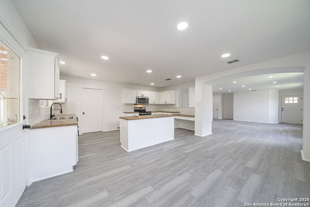 3914 Cinco Rios San Antonio, TX 78223 - Photo 5 of 12 a kitchen with stainless steel appliances kitchen island granite countertop a stove a sink and a refrigerator