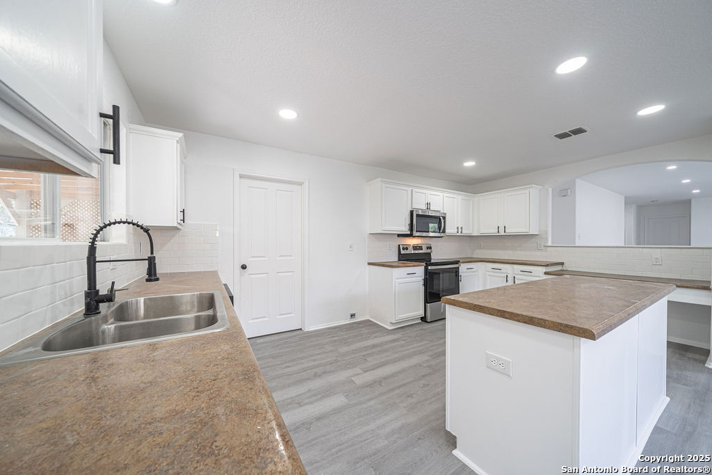 3914 Cinco Rios San Antonio, TX 78223 - Photo 6 of 12 a kitchen with a sink stove and cabinets