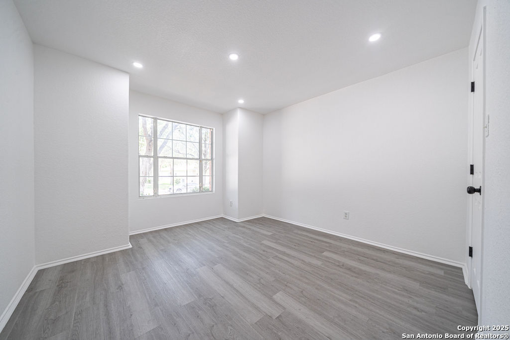 3914 Cinco Rios San Antonio, TX 78223 - Photo 7 of 12 an empty room with wooden floor and windows