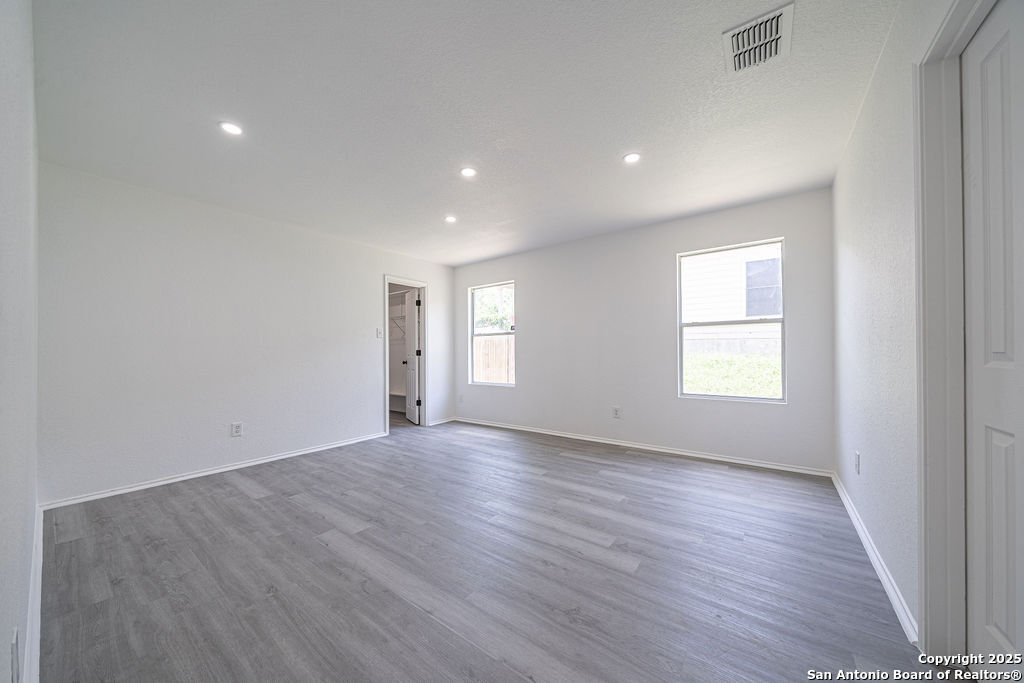 3914 Cinco Rios San Antonio, TX 78223 - Photo 9 of 12 an empty room with wooden floor and windows