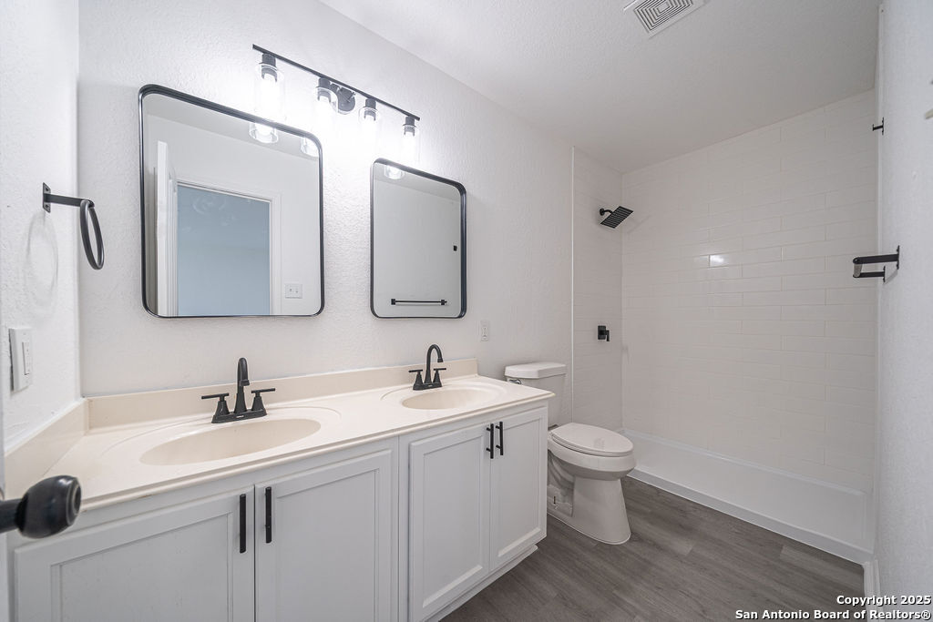 3914 Cinco Rios San Antonio, TX 78223 - Photo 10 of 12 a bathroom with a toilet sink and mirror