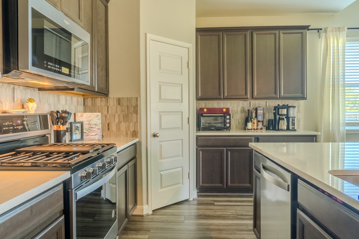 2617 Indigo Harvest Trail Pearland, TX 77089 - Photo 13 of 32 a kitchen with stainless steel appliances granite countertop a stove and a microwave