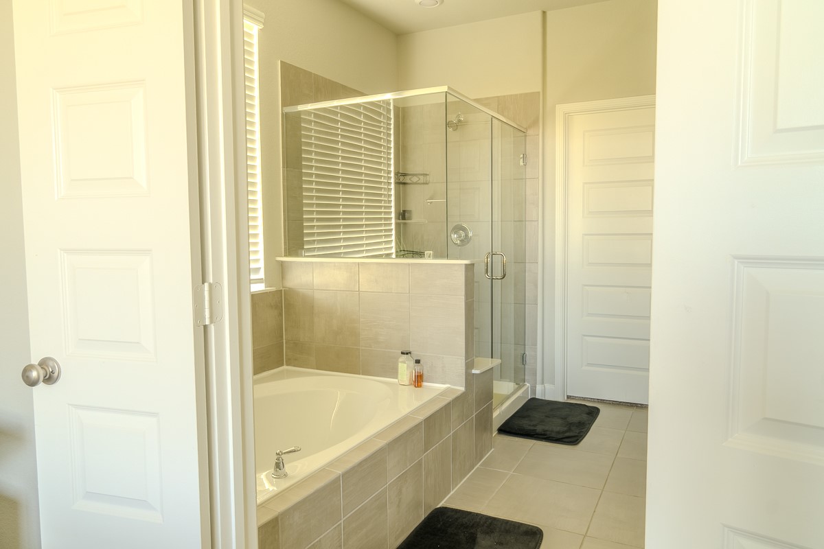 2617 Indigo Harvest Trail Pearland, TX 77089 - Photo 15 of 32 a bathroom with a tub and a shower