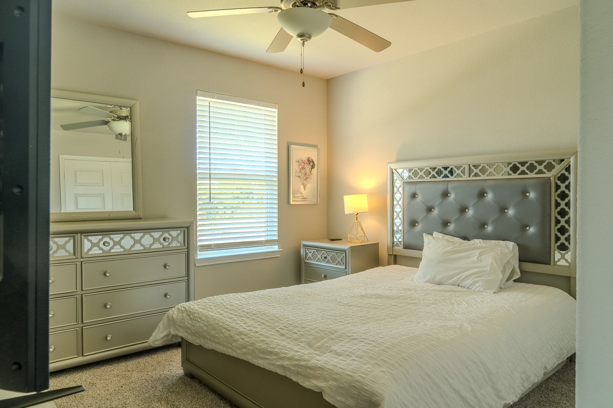 2617 Indigo Harvest Trail Pearland, TX 77089 - Photo 24 of 32 a bedroom with a bed and a chandelier