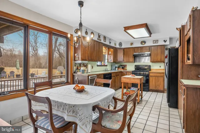 a kitchen with stainless steel appliances a dining table chairs and a view of living room