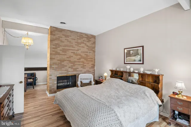 a bedroom with a bed a dresser and painting on the wall