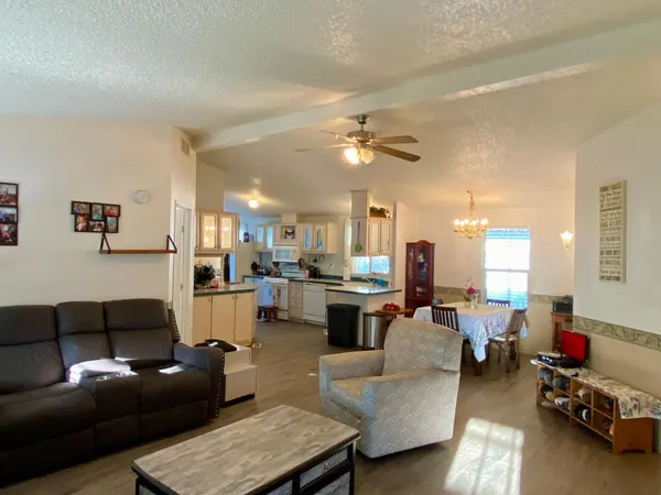a living room with furniture and a view of kitchen