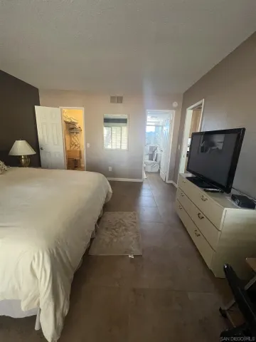 a bedroom with a bed and flat screen tv