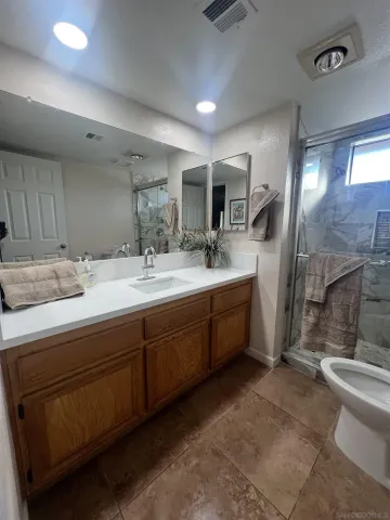 a bathroom with a double vanity sink toilet and a mirror