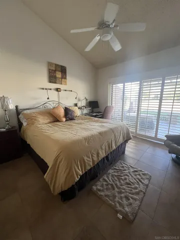 a bed sitting in a spacious bedroom next to a window