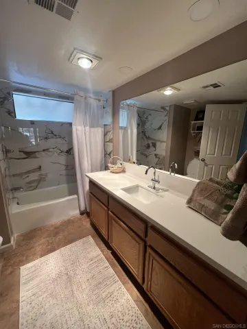 a bathroom with a double vanity sink a mirror and a bathtub