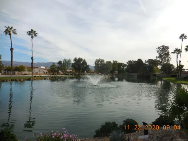 a sign of golf club on a wall under a tree