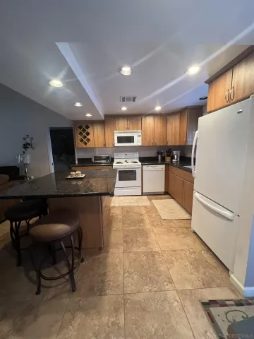 a kitchen with a refrigerator and a stove top oven
