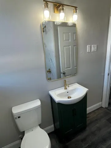 a bathroom with a toilet a sink and mirror