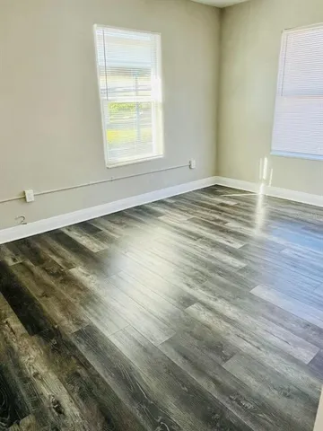a view of a room with wooden floor and window