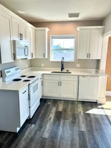 a kitchen with stainless steel appliances granite countertop a sink stove and cabinets