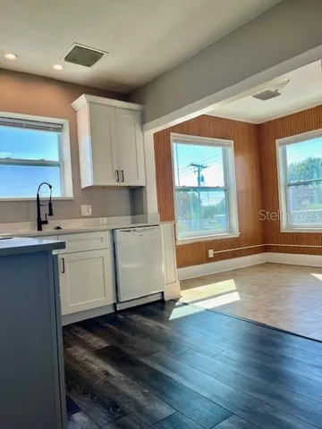 a kitchen with a sink wooden floor and a large window