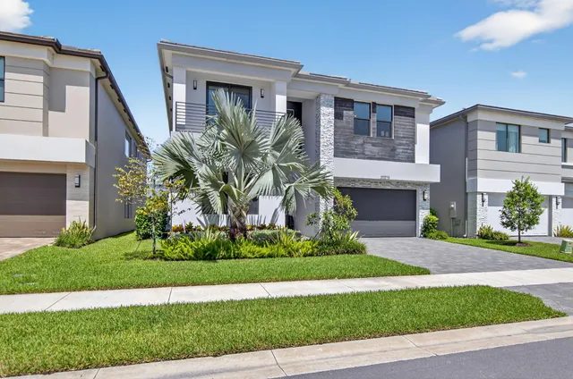 a front view of a house with a garden and plants