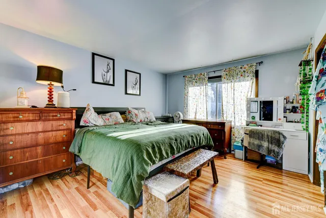 a living room with a bed and a dresser next to a window