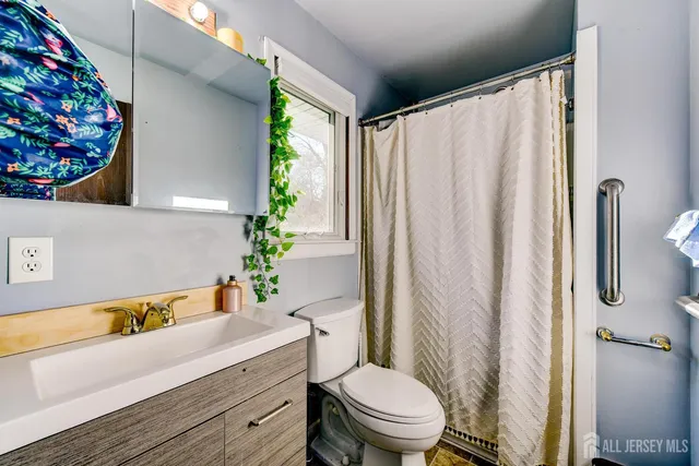 a bathroom with a sink a toilet and shower curtain