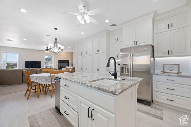 230 Boulder Way Leeds, UT 84746 - Photo 10 of 72 Main Gourmet Kitchen with a ceiling fan, stainless steel fridge, an island with sink, granite stone countertops, and recessed lighting plus nook with overhead fixture and family room with floor to ceiling stone fireplace with hearth.