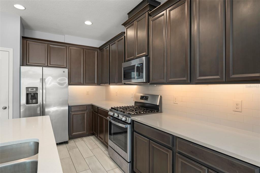 229 Rustic Loop Sanford, FL 32771 - Photo 11 of 38 a kitchen with granite countertop stainless steel appliances and wooden cabinets