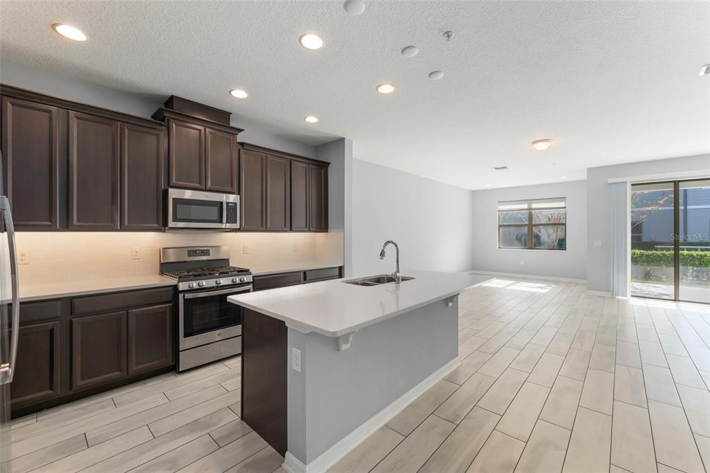 229 Rustic Loop Sanford, FL 32771 - Photo 7 of 38 a kitchen with stainless steel appliances granite countertop a stove a sink and a refrigerator