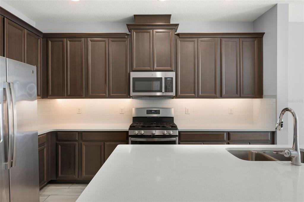 229 Rustic Loop Sanford, FL 32771 - Photo 8 of 38 a kitchen with granite countertop stainless steel appliances and wooden cabinets