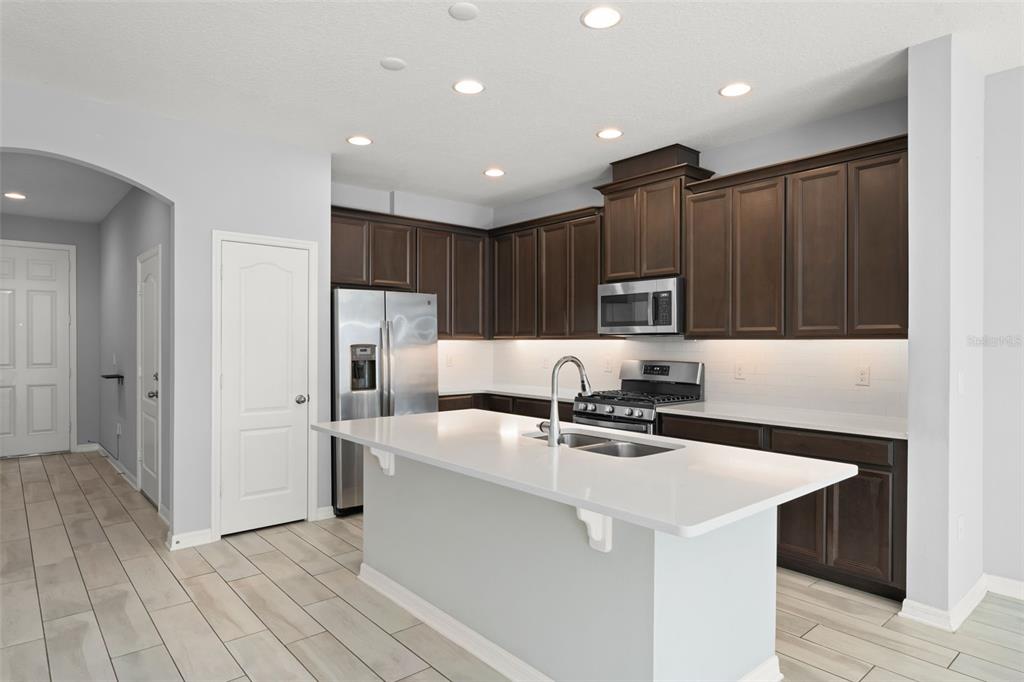 229 Rustic Loop Sanford, FL 32771 - Photo 9 of 38 a kitchen with kitchen island a sink stainless steel appliances and cabinets