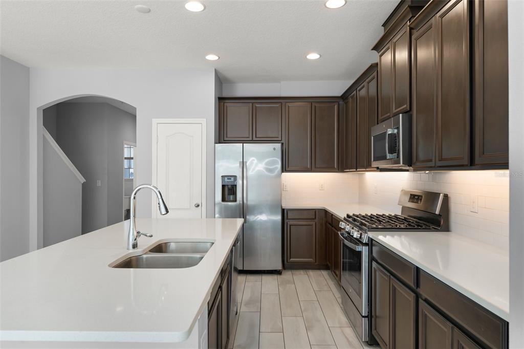 229 Rustic Loop Sanford, FL 32771 - Photo 10 of 38 a kitchen with kitchen island granite countertop stainless steel appliances and wooden cabinets