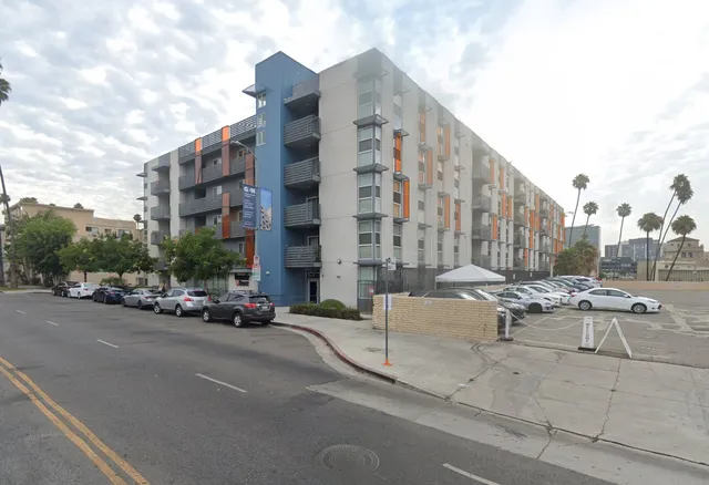 a view of a building and car parked on the road