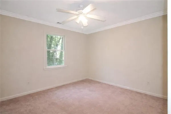 an empty room with a window and a fan