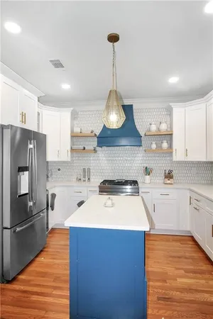 a kitchen with stainless steel appliances a sink a stove a refrigerator and cabinets