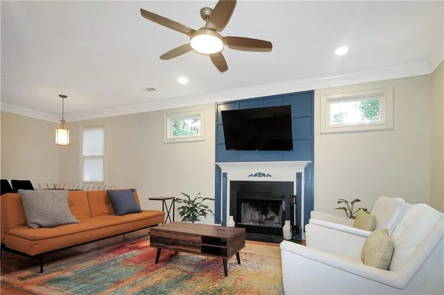 a living room with furniture a fireplace and a flat screen tv