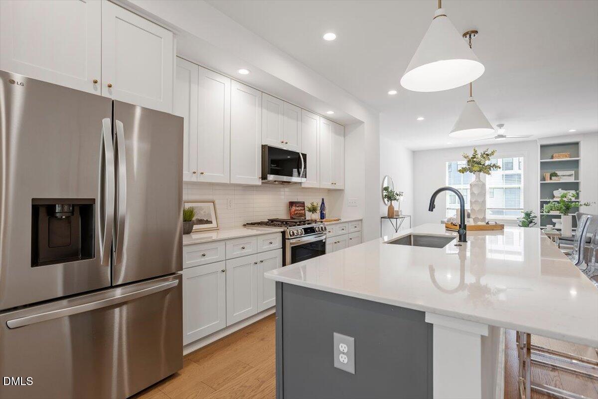 6419 Tanner Oak Lane Raleigh, NC 27613 - Photo 12 of 39 a kitchen with stainless steel appliances granite countertop a refrigerator a sink a stove top oven and a refrigerator