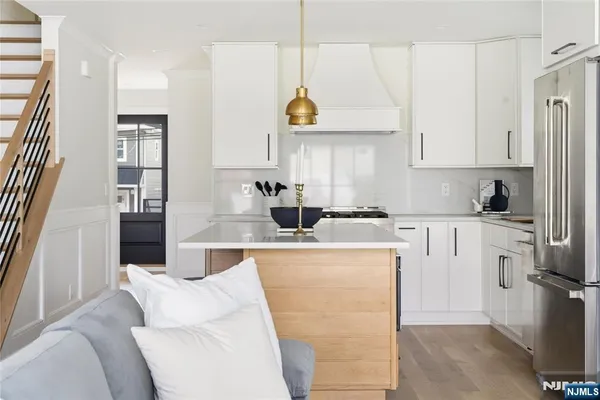 a kitchen with stainless steel appliances granite countertop a sink a stove and a refrigerator