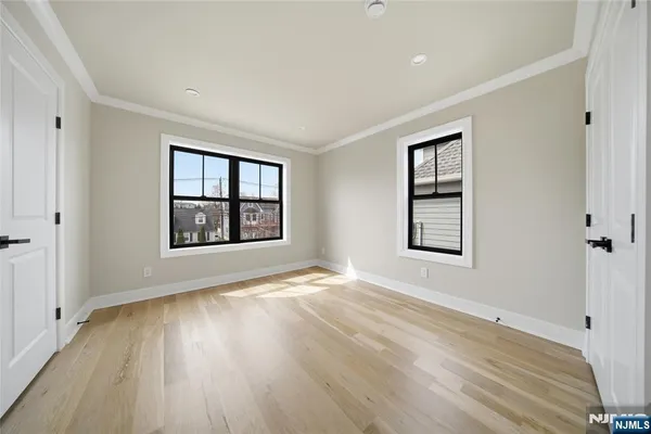 a bedroom with a bed couch and windows