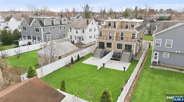 a view of a white house with a yard and plants