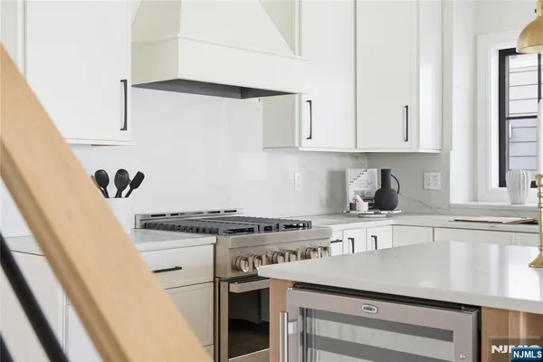 a kitchen with stainless steel appliances granite countertop a sink a stove and a refrigerator