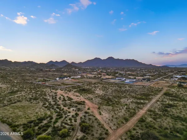a view of a lush green field with mountains in the background