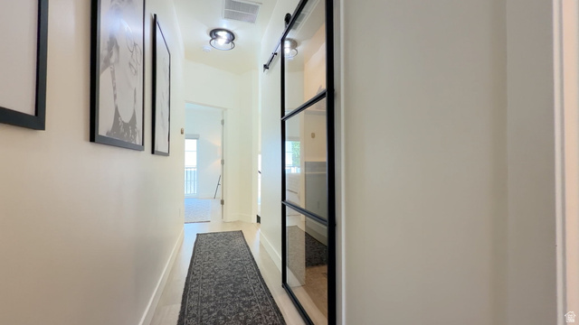 57 McCall Ln. Farmington, UT 84025 - Photo 20 of 36 Hallway featuring wood-finish flooring, recessed lighting, and a modern barn door with glass panels