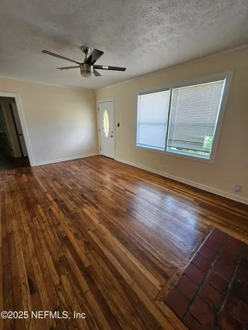 a view of empty room with wooden floor