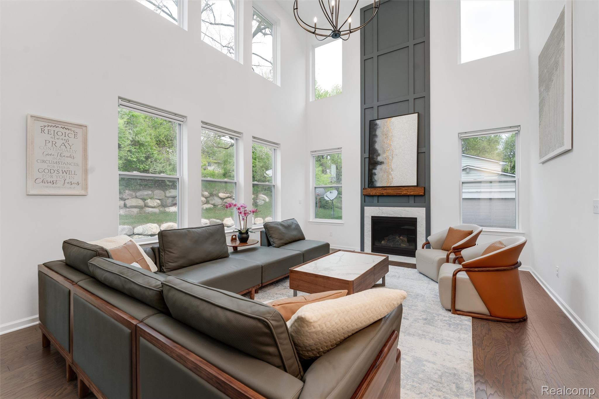 908 South Livernois Road Rochester, MI 48309 - Photo 12 of 49 Living area featuring a large fireplace, hanging lights, wood finished floors, and a high ceiling