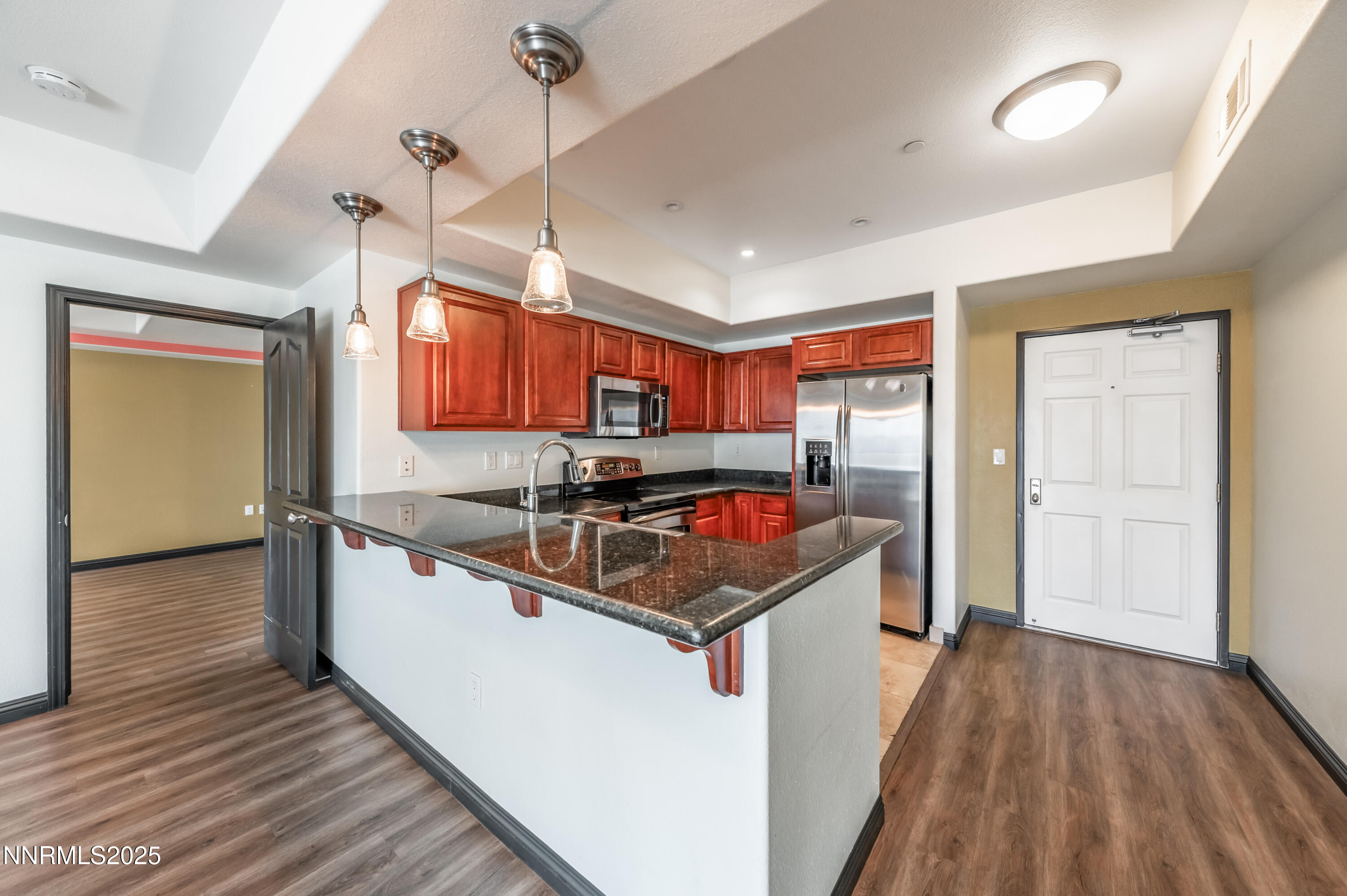200 West 2nd Street, Unit 1101 Reno, NV 89501 - Photo 4 of 38 a kitchen with stainless steel appliances granite countertop a sink and wooden floor