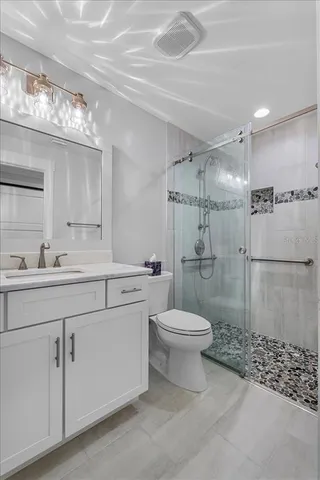 a bathroom with a sink a toilet and shower