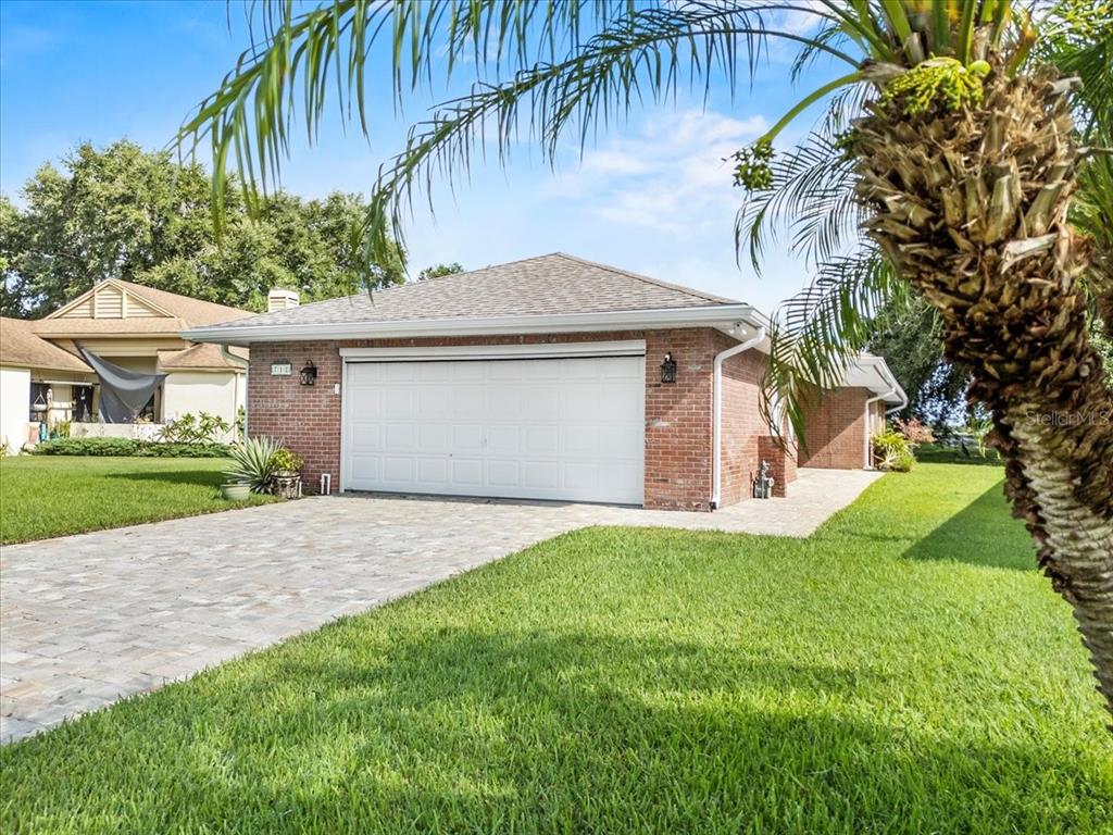 718 Canberra Road Winter Haven, FL 33884 - Photo 30 of 36 a front view of a house with a yard and garage