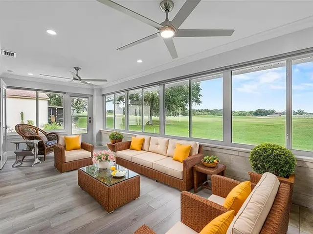 a living room with furniture and floor to ceiling windows