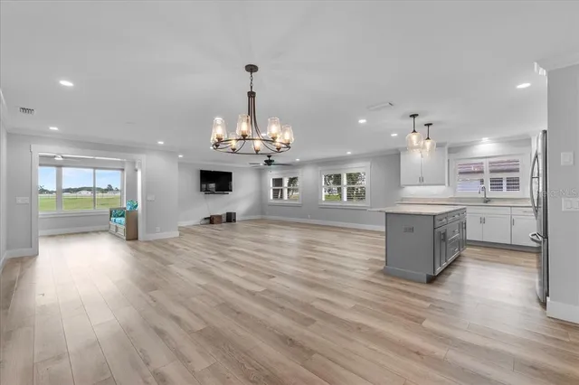 a view of a kitchen with kitchen island stainless steel appliances sink refrigerator and microwave