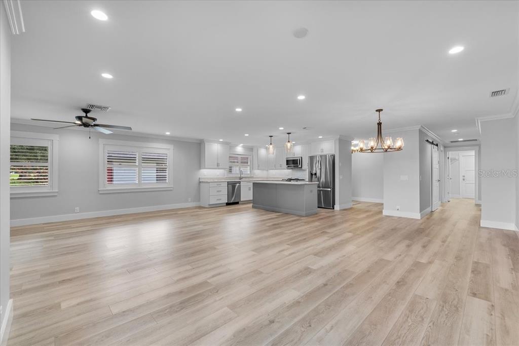 718 Canberra Road Winter Haven, FL 33884 - Photo 10 of 36 a view of a kitchen with a sink dishwasher a kitchen island a stove and a wooden floors