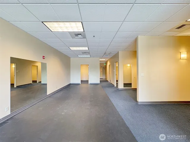 a view of a hallway with wooden floor and a window